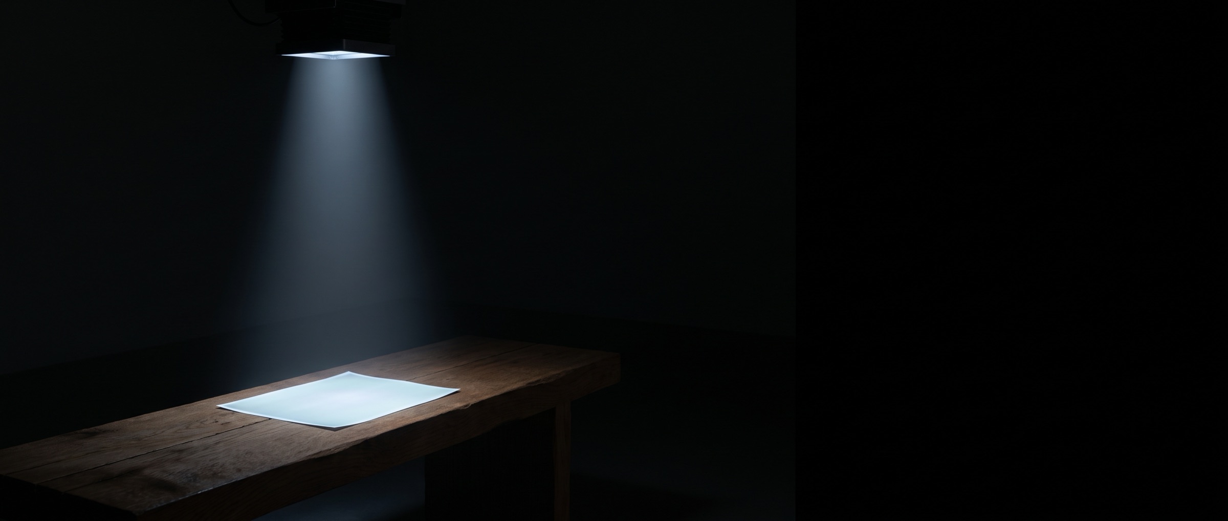 An enlarger's light column falling on a sheet of paper